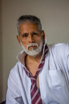 Confident Senior Businessman with Open Collar and Loose Tie