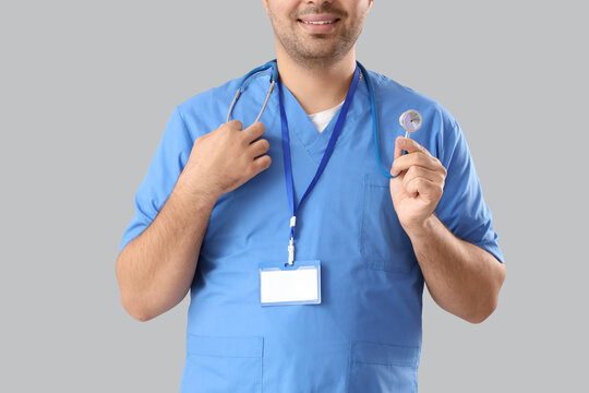 Male doctor with stethoscope  on grey background
