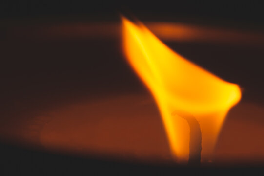 Close-up of burning candle wick with glowing flame