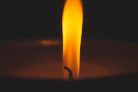 Close-up of burning candle wick with glowing flame
