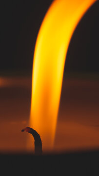 Close-up of burning candle wick with glowing flame