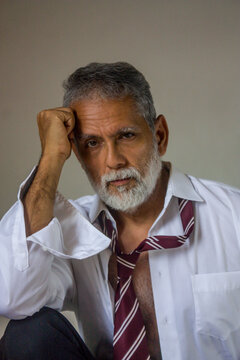 Pensive Mature Man Touching Temple in Loose Shirt and Tie