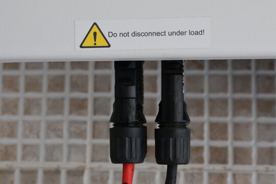 Close up of solar panel connectors with warning label Do not disconnect under load