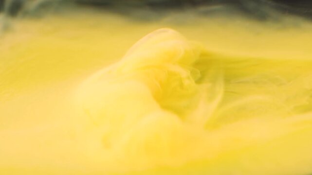 Shooting paint underwater to create patterns with yellow acrylic colors