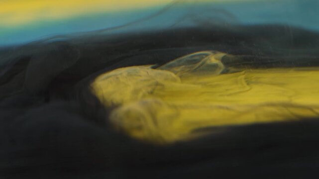 Shooting paint in water with ink spreading and mixing underwater