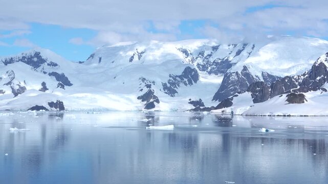 Antarctica Rugged Snow-Capped Mountains, Icebergs Pristine Polar Wilderness Nature Epic Landscape. Beautiful Bismarck Strait. Blue Sky Day Calm Waters