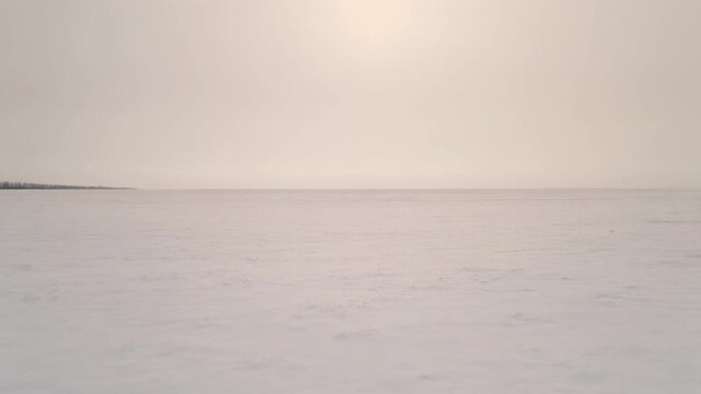 Wide Angle Shot of a Vast Snow Covered Field Under a Pale Winter Sky, Calm Overcast Cold Landscape