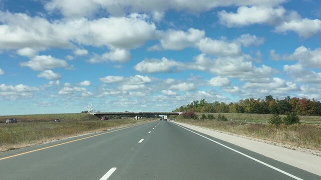 Driving on a Highway Under a Clear Sunny Sky With Clouds