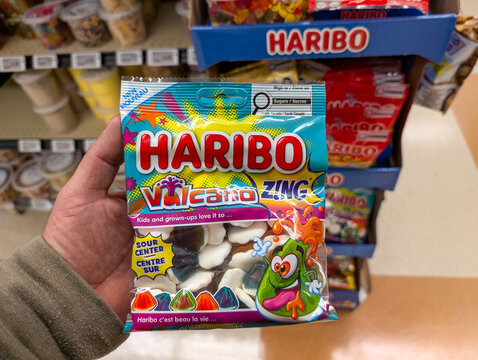 Quebec, Canada, 11 May 2026 : A hand holds a bag of Haribo Vulcano Zing sour center candies in a store aisle.