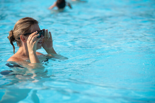 Happy Woman Relaxing in a Sunny Outdoor Swimming Pool
