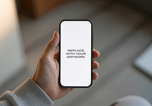 Smartphone screen mockup held in hand displaying white with placeholder text, realistic mobile device presentation indoor environment natural light, vertical orientation