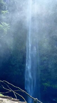 Coban Rondo Waterfall Cascading Through Lush Tropical Forest in Indonesia