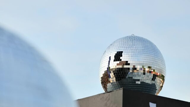 Disco ball reflecting the clear sky and surroundings, symbolizing celebration