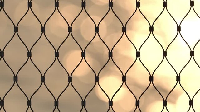 Metallic wire mesh pattern creating a geometric barrier with golden bokeh background