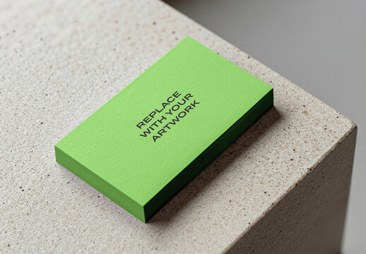 Business card mockup featuring a stack of bright green cards on textured stone surface, realistic stationery presentation with placeholder text, office desk environment, print design template