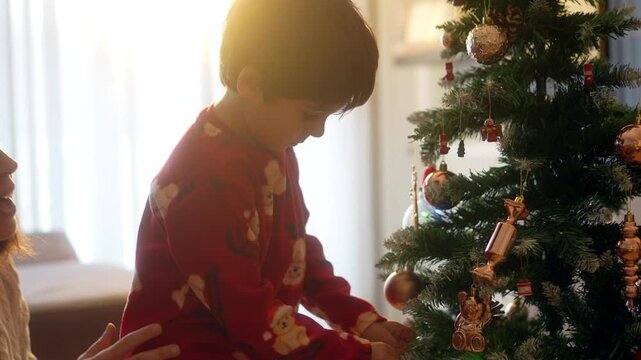 Mother and son decorating christmas tree and giving high five
