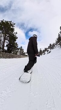Snowboarder riding down a snowy mountain slope