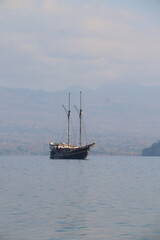 Traditional Pinisi Sailing Boat on Calm Sea with Tropical Island Background © Nawassyarif .
