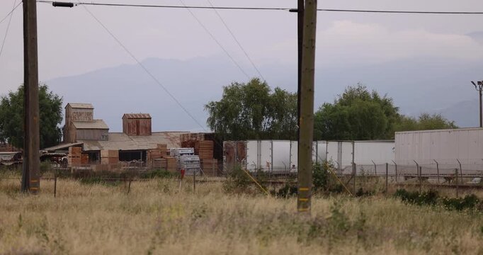 Cloudy daytime view of historic buildings and housing in downtown Chualar, California, USA.