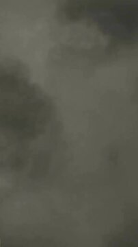 Animation of gray sculpture of man over dark sky and clouds, copy space