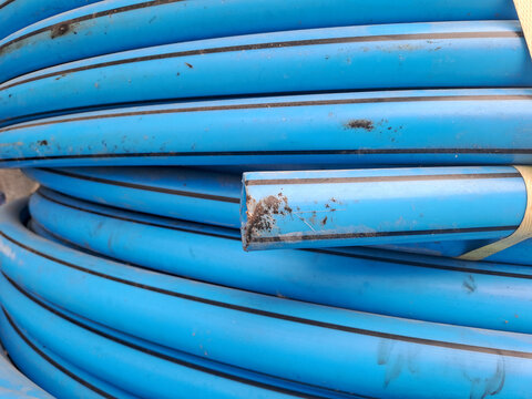 Roll of blue plastic polyethylene pipes for water supply and plumbing construction	