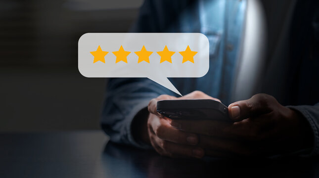 close up on customer man hand pressing on smartphone screen with gold five star rating