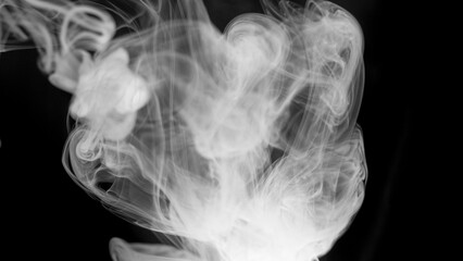 A dense and voluminous mass of white smoke drifts and flows, exhibiting delicate tendrils and ethereal patterns on a black canvas. © Ahmad Khan