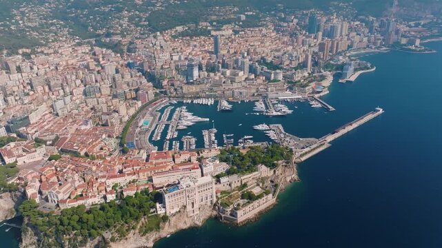 Footage captures Monacos skyline along the coastline. The overview highlights buildings, docks, and the layout of city streets. The view illustrates the busy harbor area and urban development.