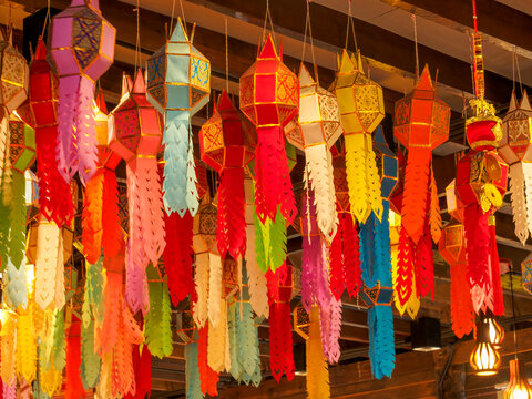 Group of traditional colorful Thai paper lanterns hanging from ceiling as background decoration.Lanna Paper Lanterns / Yi Peng Hanging Lanterns