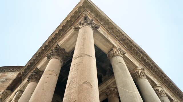 Ancient architectural columns standing tall against a bright sky, showcasing detailed craftsmanship and historical grandeur.