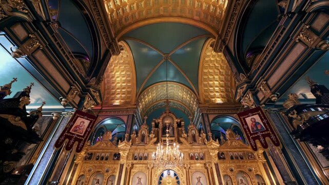 Stunning interior view of ornate orthodox church with golden iconostasis and intricate architectural details in panning motion.