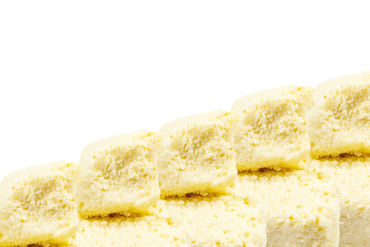 Close-up of white, crumbly cheese cubes arranged in a rising diagonal pattern against a clean, isolated white background
