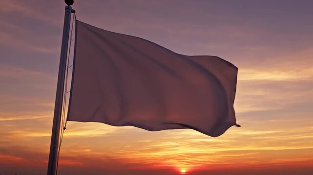 A Blank White Flag Waves on a Pole Against a Beautiful Sunset Sky