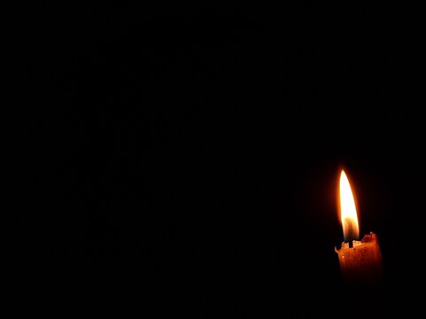 Candle light in the dark background with copy space.