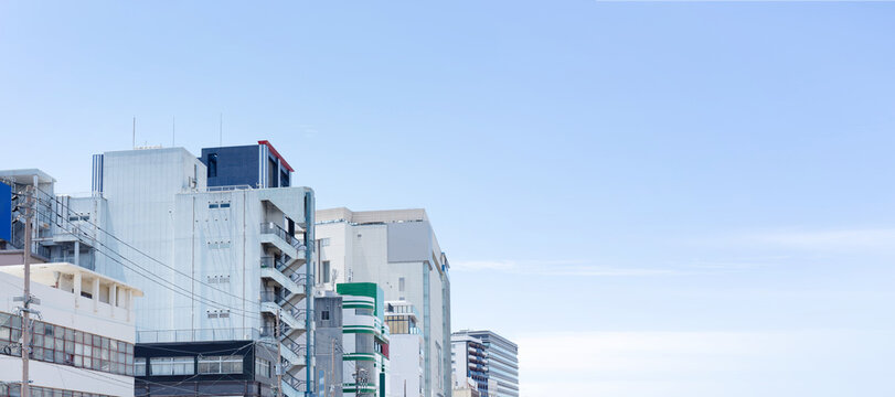 Panoramic view of mixed commercial buildings with expansive blue sky copy space in Fukuoka, Japan