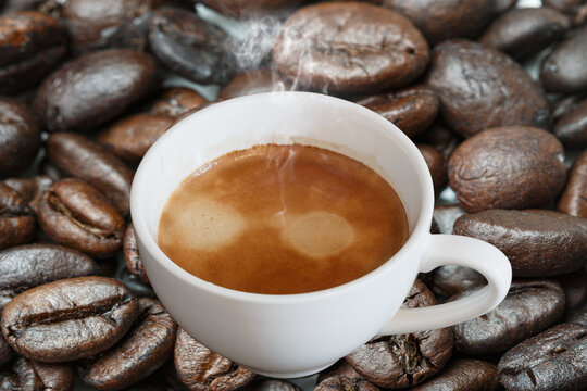 Hot black coffee in white cup  on a coffee bean   background