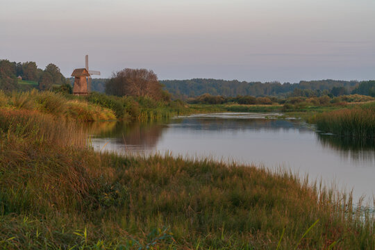 An ancient wooden windmill on the banks of the Sorot River on a foggy summer morning, Mikhailovskoye, Pushkinskiye Gory, Pskov region, Russia