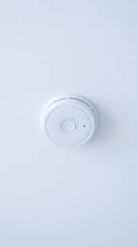 Smoke detector on white wall for occupational health and safety, minimal home safety device