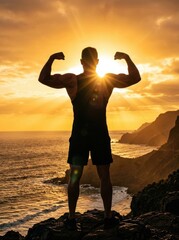 Fototapeta premium Strong Bodybuilder Silhouette Flexing Biceps on a Rocky Cliff at Golden Sunset Overlooking the Ocean