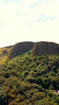 Anti-clockwise 60FPS vertical social ratio aerial video of Cavehill in North Belfast, Northern Ireland in the UK on a bright sunny day. Produced with Rec709 colour.
