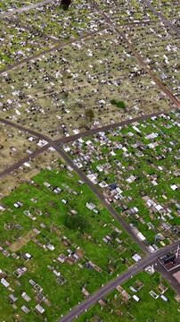 Rising 60FPS vertical social ratio aerial video of Milltown Cemetary and the Republican Plot in West Belfast, Northern Ireland in the UK on a bright sunny day. Produced with Rec709 colour.