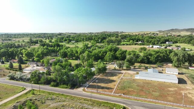 Drone shot capturing the transitional zone between suburban acreage and rugged mountain topography in Loveland, CO.