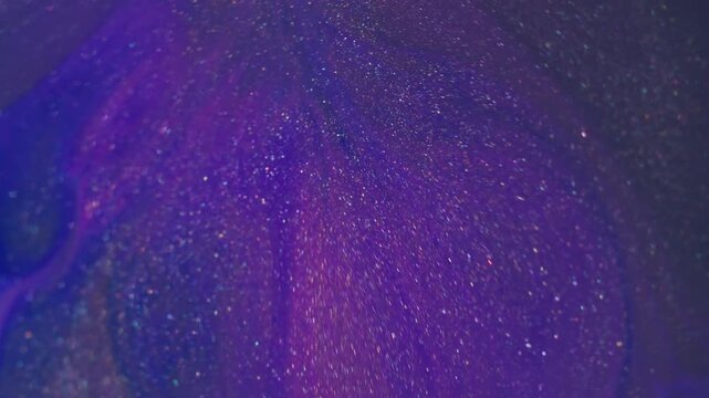 Ink spatter. Pigment mix. Defocused blue purple colorful glitter flowing shiny texture floating on abstract creative art background.