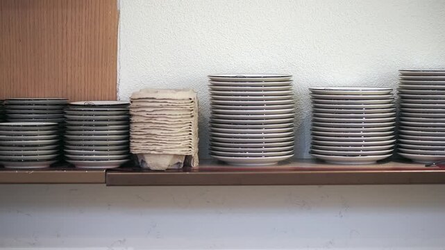 Stacked plates and napkins on a restaurant shelf