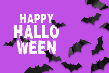 Fototapeta premium Halloween. Bats scatter across bright purple background with happy halloween text