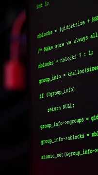 Programming code scrolling on dark computer screen during software development process.