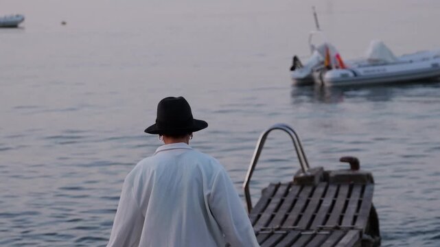 Solitary traveler enjoying a serene moment by the water during early morning