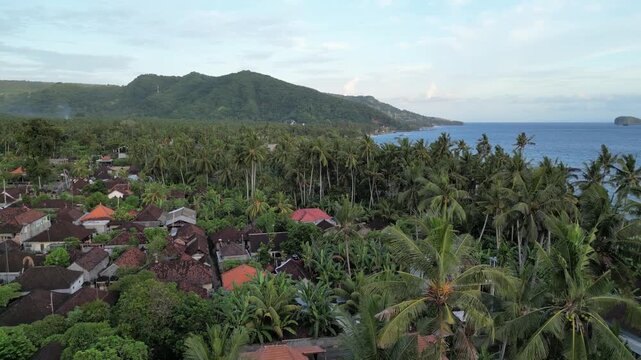 Aerial view of Candi Dasa with palms green hills blue harbor in Bali, Indonesia.