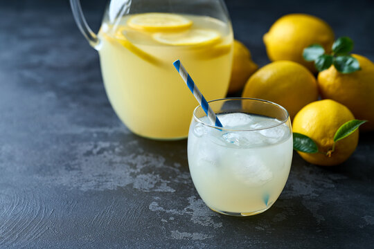 Refreshing homemade summer lemonade in glass with ice on a black table, selective focus. Cold refreshing lemonade .