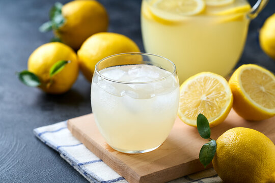 Refreshing homemade summer lemonade in glass with ice on a black table, selective focus. Cold refreshing lemonade .